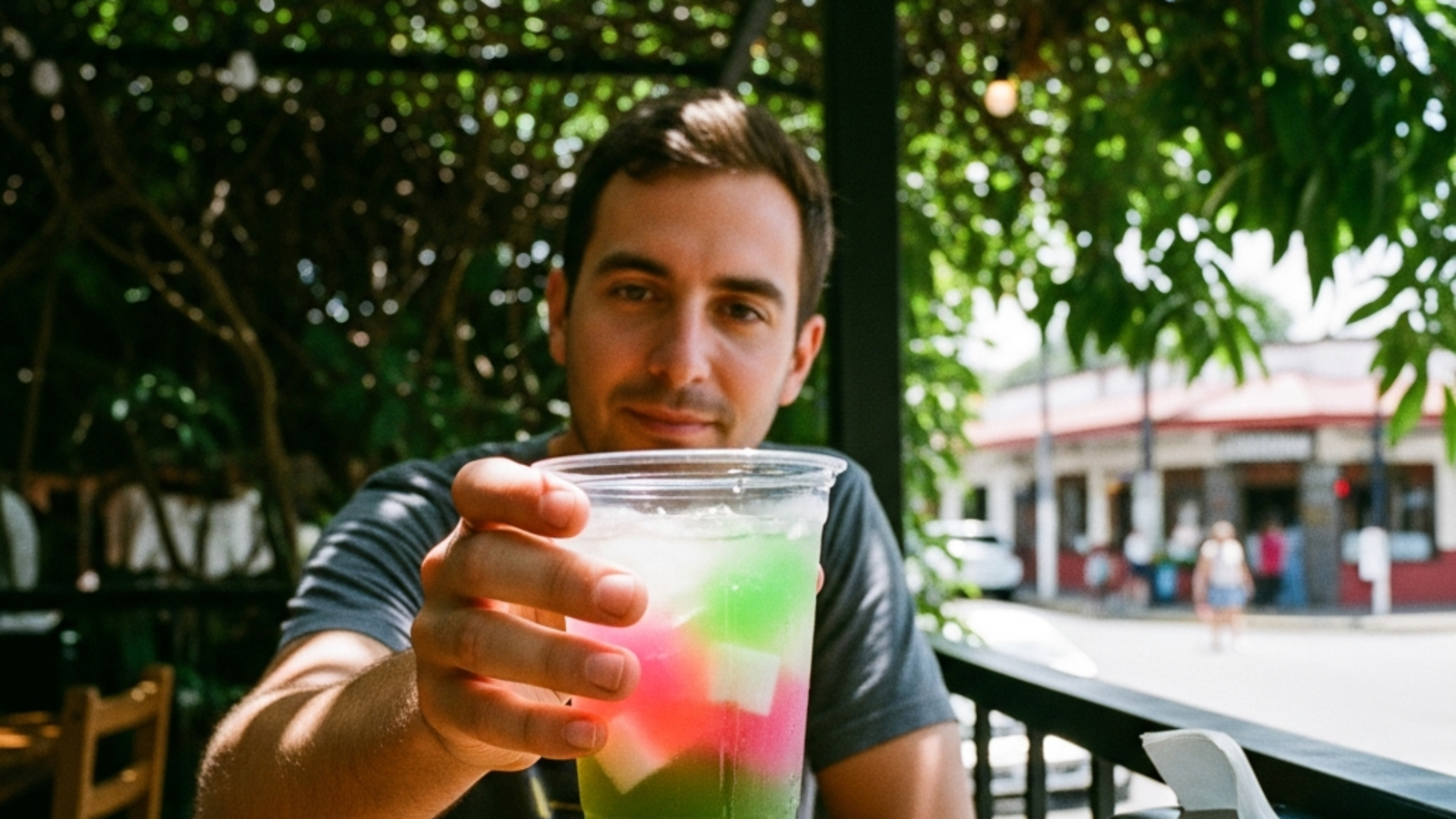 Vaso de té verde de jazmín con cubitos de rainbow jelly en terraza soleada