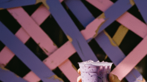 Vaso de té con leche con taro morado y fresa rosa con hielo